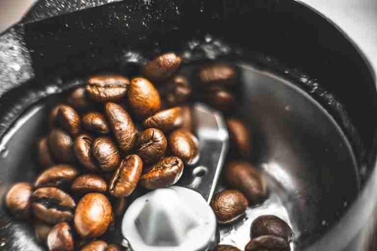Fresh coffee beans in a grinder, ready for brewing a delicious cup of coffee.