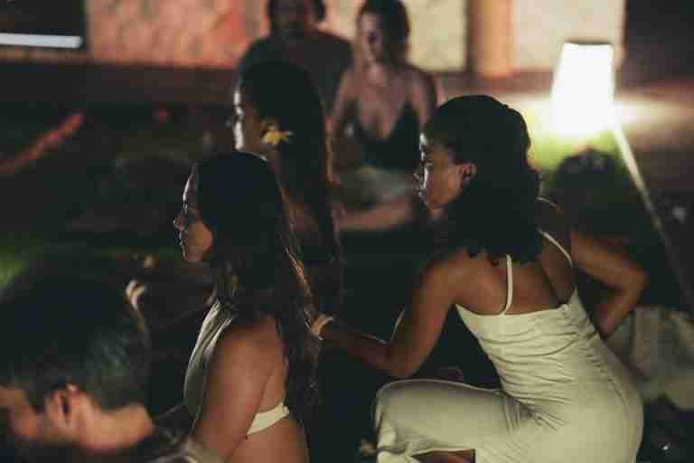 A serene group meditation session by candlelight indoors promoting relaxation and mindfulness.