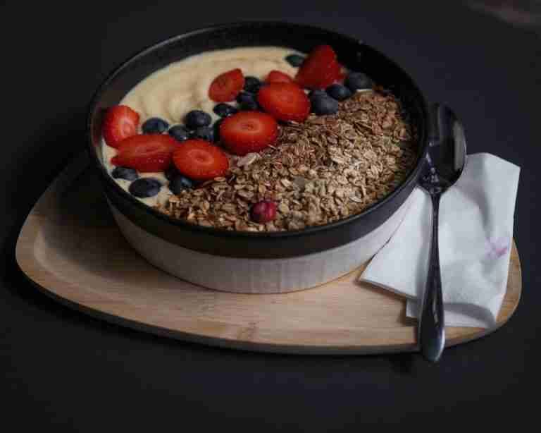 Delicious breakfast bowl with granola, strawberries, blueberries, and yogurt, perfect for a healthy start to the day.