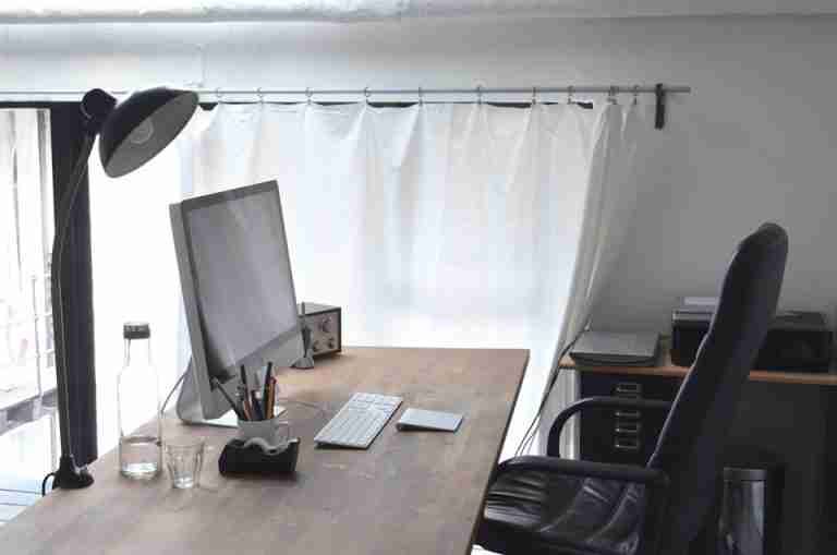 Clean and stylish minimalist office workspace with contemporary furnishings and natural lighting.