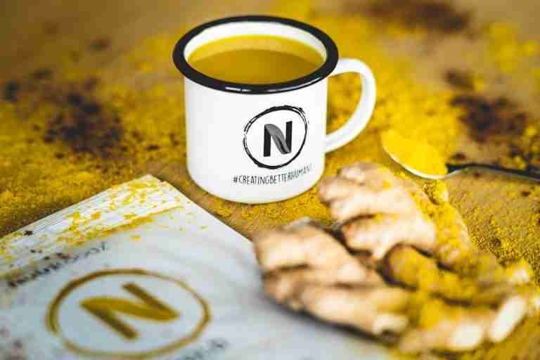 A close-up image of turmeric tea with fresh ginger root, perfect for health and wellness themes.