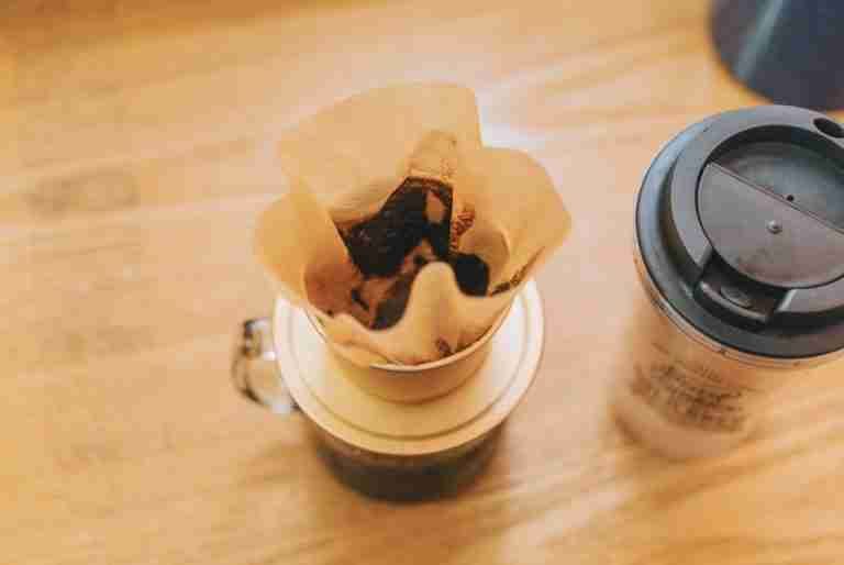 Coffee brewing with a pour-over filter on a wooden table for a cozy morning ritual.