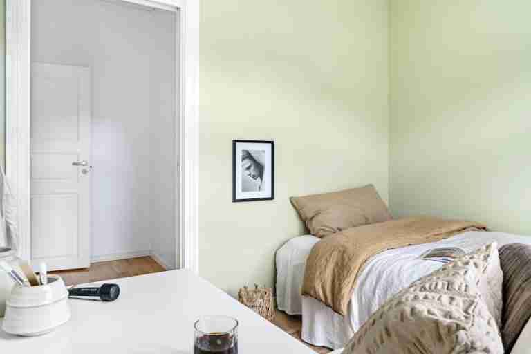 A simple and comfortable minimalist bedroom with natural tones and soft lighting.