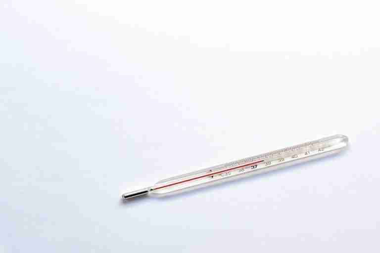 A glass clinical thermometer on a plain white background, symbolizing healthcare and medical precision.