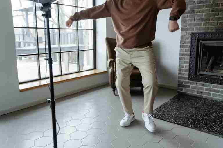 A senior man enjoying a dance in a modern living room setting.