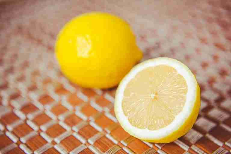 Close-up of lemon halves showcasing vibrant color and texture on a woven surface.