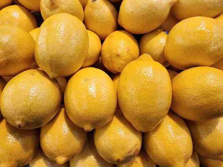 Bright yellow lemons clustered together, showcasing fresh produce appeal.