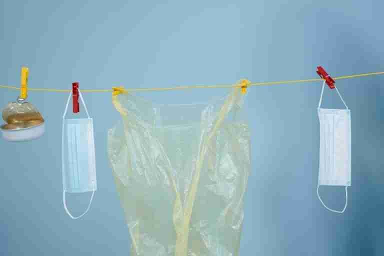 Studio image of household items like masks and cans on a clothesline symbolizing recycling efforts.