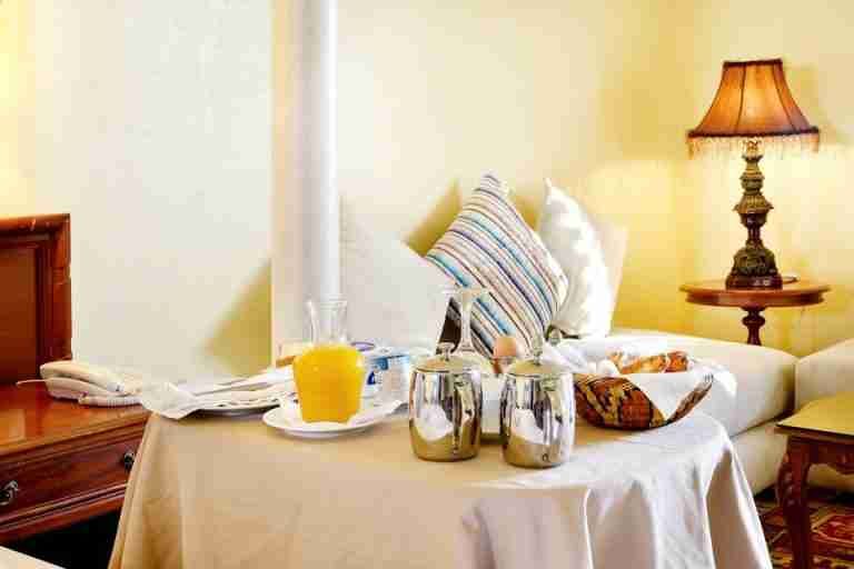 A cozy indoor breakfast setting with elegant décor, featuring croissants and orange juice.