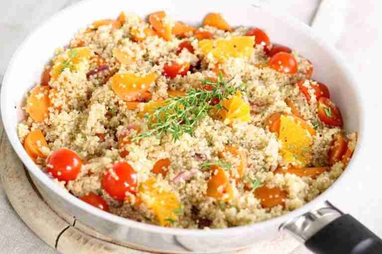 Delicious vegan quinoa salad with tomatoes, oranges, and fresh herbs.