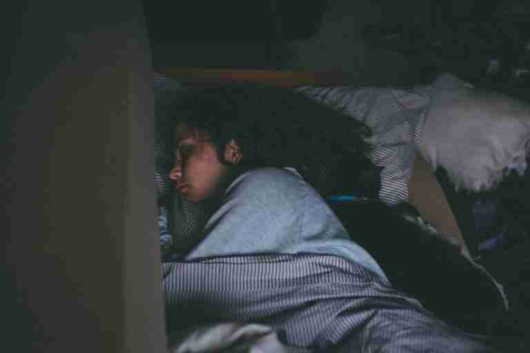 A woman sleeping peacefully with her cat, capturing a serene and cozy nighttime scene.