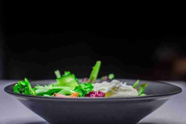 Close-up of a colorful fresh garden salad in a stylish black bowl.