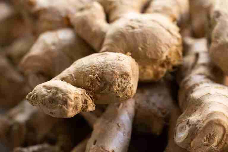 Detailed view of fresh raw ginger roots, showcasing texture and earthy tones. Ideal for food themes.