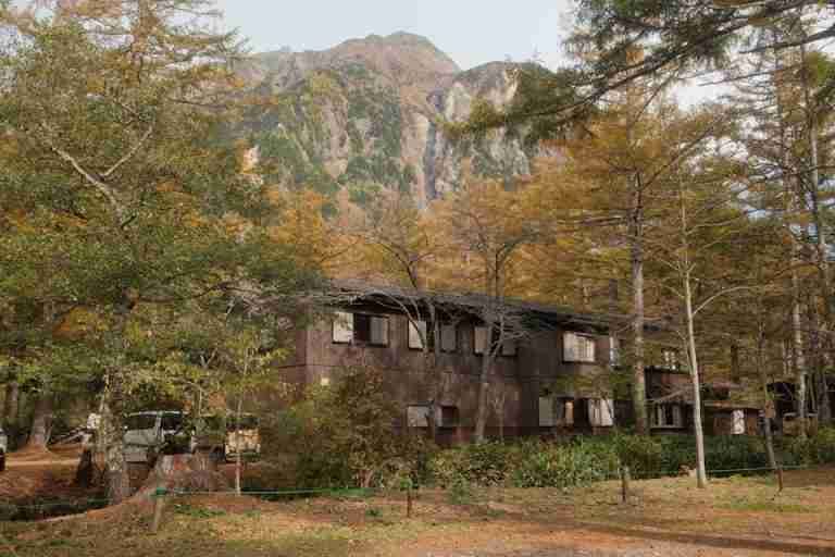 Cozy rustic cabin amidst autumn foliage and mountains in Matsumoto, Nagano, Japan.