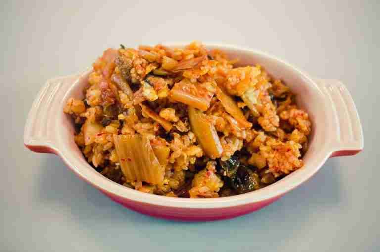 Tantalizing Korean Kimchi Fried Rice served in a ceramic bowl, showcasing vibrant colors and textures.