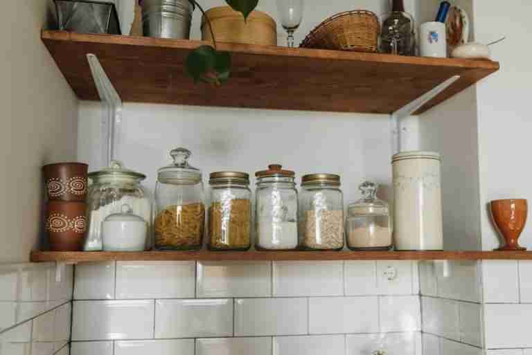 Aesthetic kitchen shelves displaying various jars and containers for organized storage.