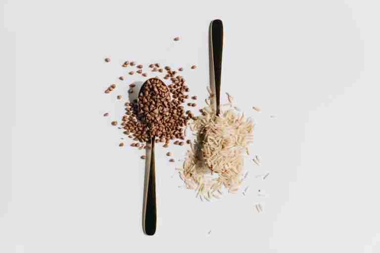 Artistic flat lay of grains with spoons on a white background. Perfect for culinary themes.