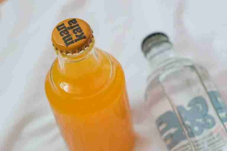 Top view of orange juice and soda bottles on a white background. Ideal for food and drink topics.