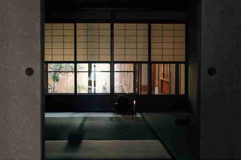 Serene Japanese room featuring tatami mats and Shoji screens, perfect for meditation or tea ceremony.