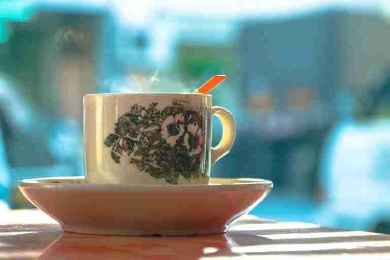 A close-up of a steaming coffee cup with floral design, perfect for a cozy morning.