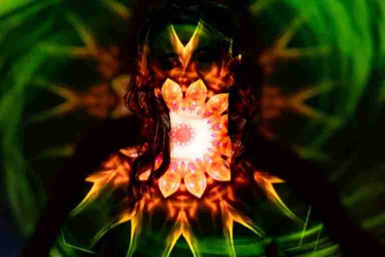Colorful kaleidoscope projection creating a vibrant aura on a woman.