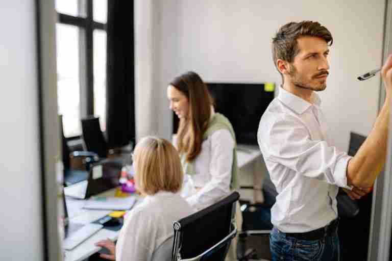 A focused team working together in a modern office setting, brainstorming and collaborating.