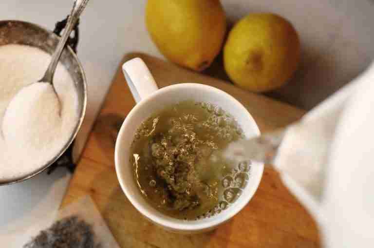 Top view of pouring fresh hot tea with lemons and sugar on the side. Perfect for a cozy morning.