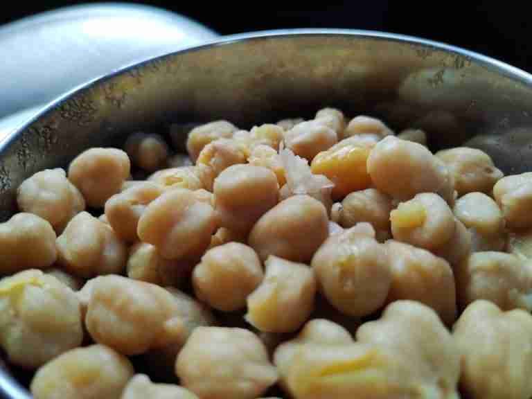 High angle view of cooked chickpeas in a metal bowl, showcasing a healthy vegan food option.