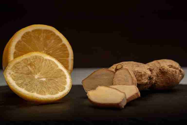 Close-up of fresh ginger root and lemon slices, highlighting their vibrant natural textures and health benefits.