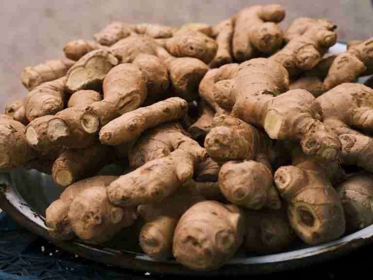 Close-up of fresh ginger roots in a bowl, highlighting its organic texture and earthy color.