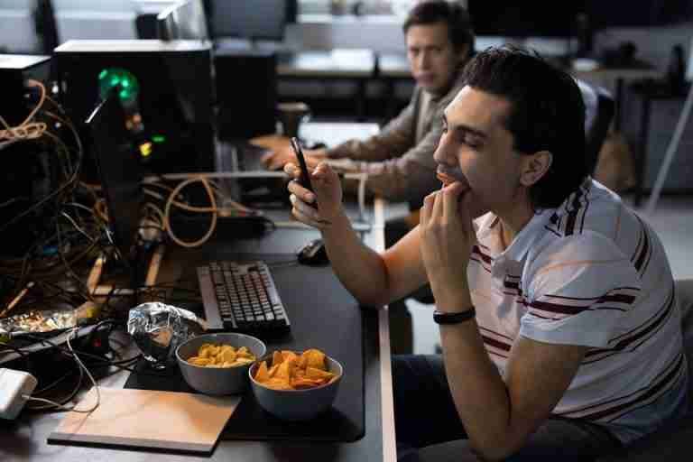Men taking a break from coding, enjoying snacks at a tech startup office.