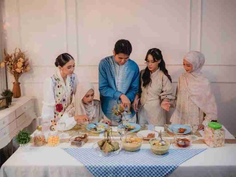 A diverse group gathered around a table for a joyful Ramadan iftar in Jakarta, Indonesia.